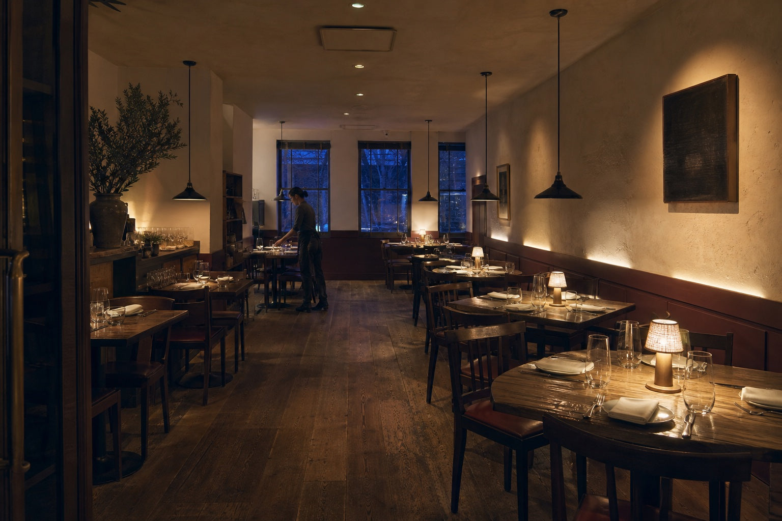 A restaurant dining room showing ambient, focal, wall, and table-level light during a pre-service check