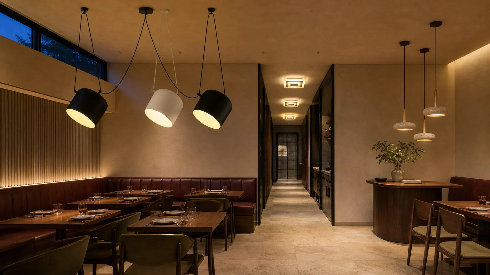 A dining room with high clerestory glazing, daylight falling across tables alongside warm electric light