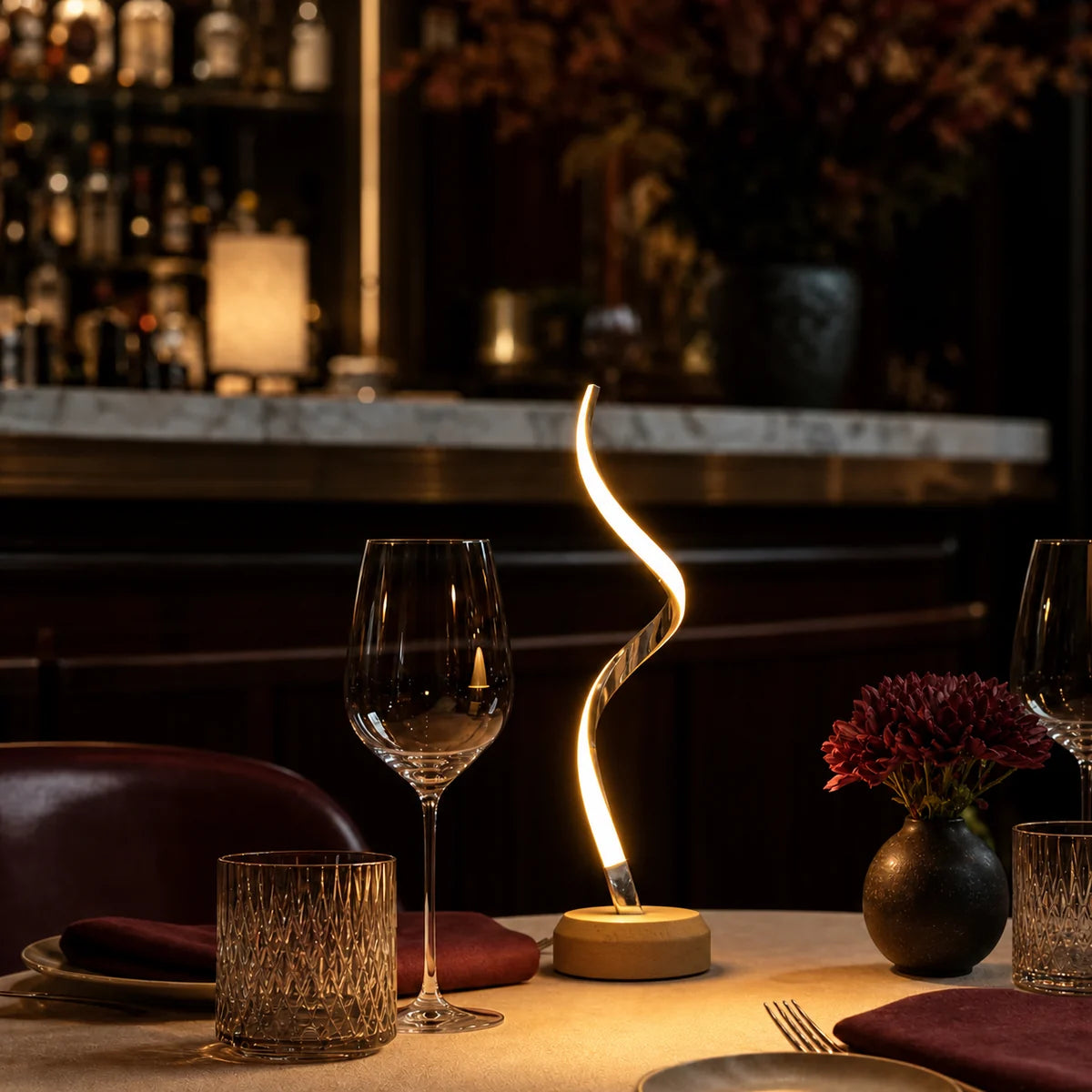 A restaurant tabletop arranged with linen, tableware, and a compact centerpiece