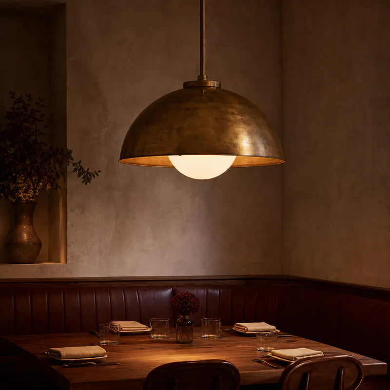 A brass pendant above an intimate restaurant table