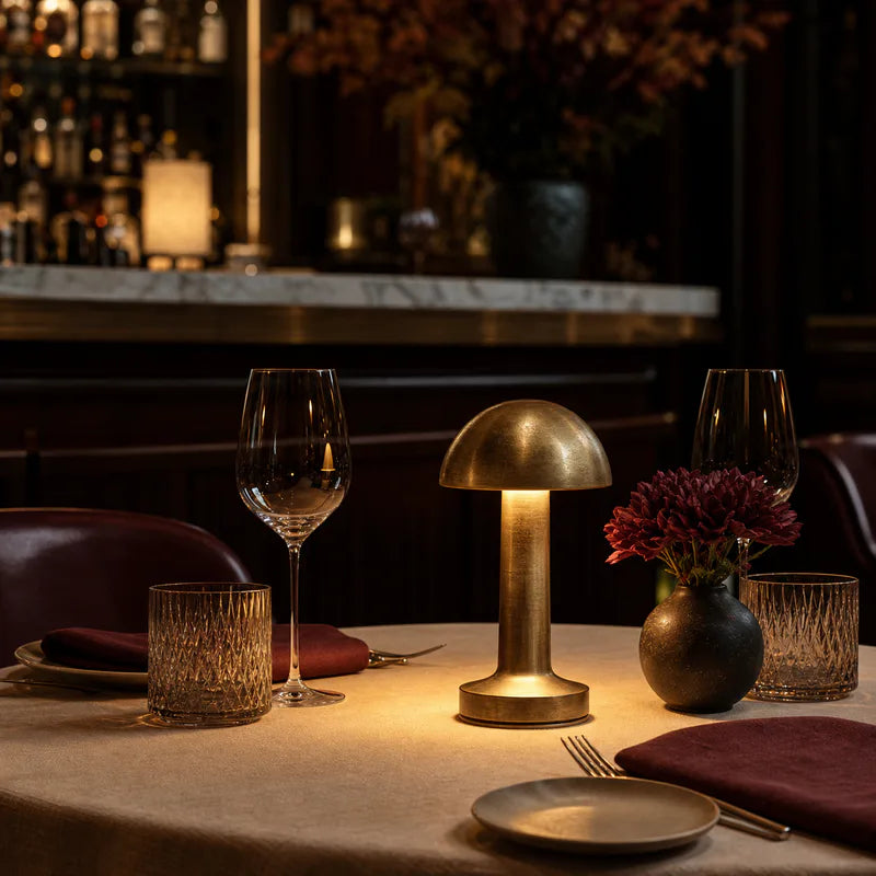 A small brass table lamp glowing on a restaurant table